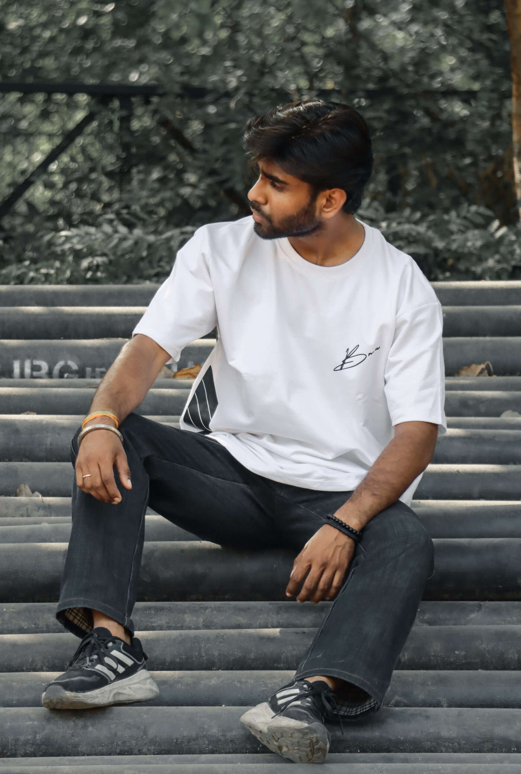 Model wearing BNGRBL BMW M4 Sports White Oversized T-Shirt with minimalist front logo, relaxed oversized fit, premium white streetwear t-shirt.